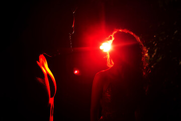 Pig masked man and woman in dramatic red neon Halloween horror scene