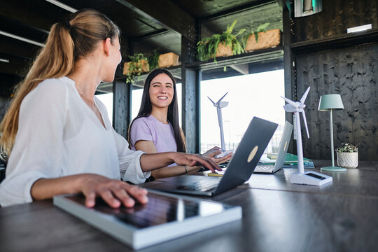 Young women testing solar panel while working at coworking space