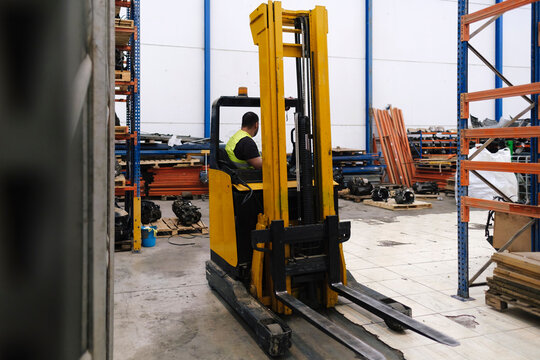 Mechanic sitting in forklift at workshop