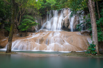 Sai Yok Noi Waterfall in Kanchanaburi, Thailand, is a charming spot surrounded by lush forest, a gentle cascade, peaceful nature, and beautiful scenery.