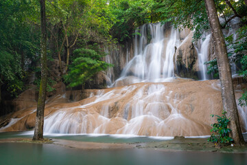 Sai Yok Noi Waterfall in Kanchanaburi, Thailand, is a charming spot surrounded by lush forest, a gentle cascade, peaceful nature, and beautiful scenery.