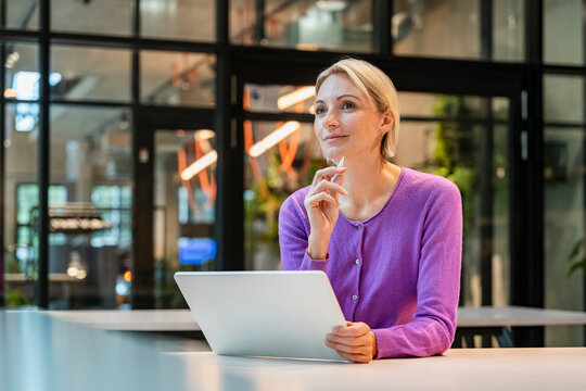 Thoughtful businesswoman working with tablet in modern office