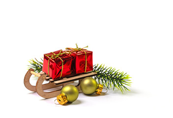 Schlitten mit Weihnachtspäckchen vor weißem Hintergrund
