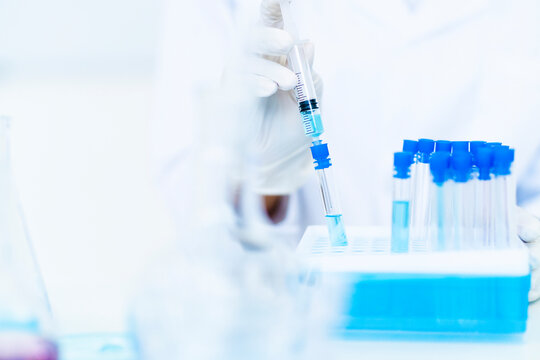 Researcher injecting liquid in test tube at laboratory