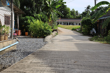 Dirt road with a house on the right side of it