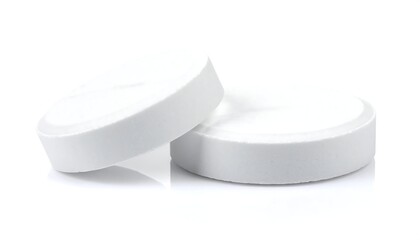Two white, circular tablets, one slightly tilted, isolated on a bright white background