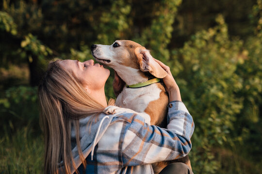 Pet owner hugging beagle dog outdoors showing companionship and care