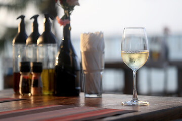 glass of cold white wine on the summer seashore by the water, relaxing by the water, a gentle background of soft color