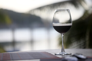 Wine glass close-up in real life, beautiful blurred background of the drink in the glass