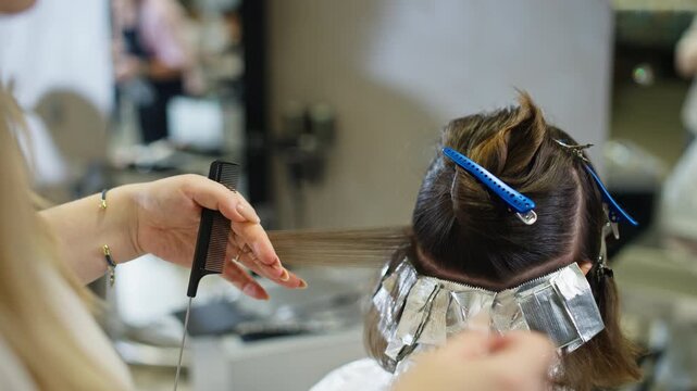 Hairdresser colors client hair in professional beauty salon with hairstyle fashion beauty treatment wellness procedure haircare services and modern appearance makeover