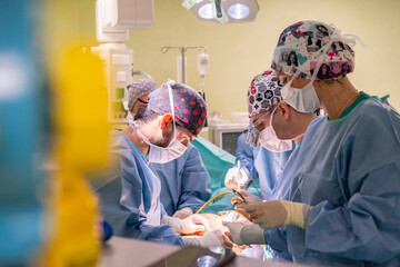 Team of surgeons wearing masks performing surgery on patient in emergency room