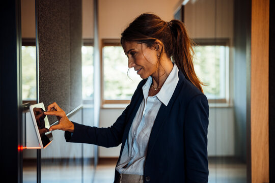 Businesswoman using touchscreen sensor in modern office meeting area