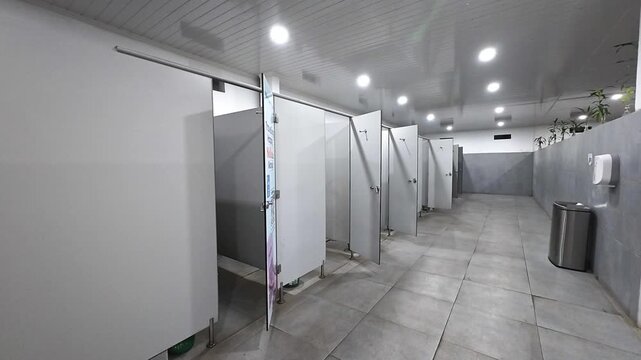 Public restroom stalls with bright lighting
