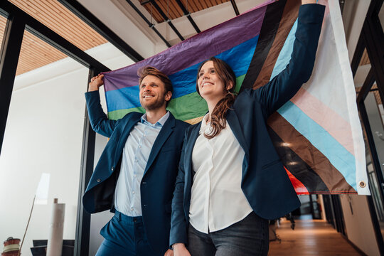 Business team holding pride flag celebrating unity and diversity