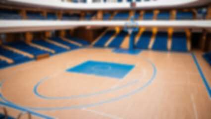 Blurred background of the interior of a basketball court located inside a modern cruise ship with complete facilities around it, without any bright lights.