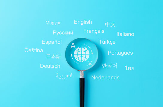 Multilingual language translation technology concept. Magnifying glass focusing on global translation icon surrounded by words in various international languages. translate, multilingual communication