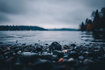 Rocky shoreline meets calm water, cityscape glows in background