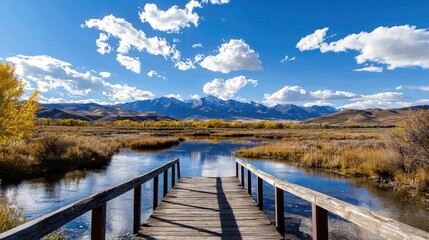 Fototapeta premium Scenic River View with Wooden Dock Under Bright Blue Sky and Fluffy White Clouds in Mountainous Landscape