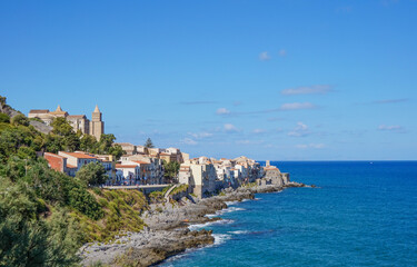 Scenic view of the historic coastal town of Cefalù in Sicily, with its Norman Cathedral and houses built along the rocky shoreline of the Tyrrhenian Sea