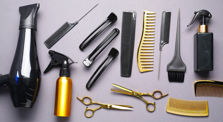 Different hair styling tools on grey background, flat lay