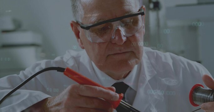 Using red-handled iron technician in white coat and goggles melting solder on wire at lab bench - Powered by Adobe
