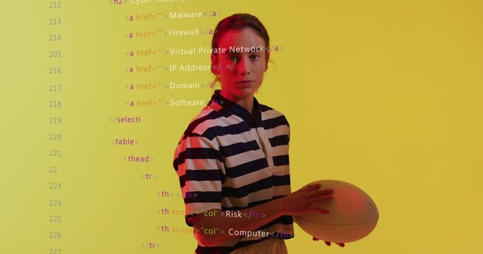 Standing woman holding rugby ball and wearing striped jersey in studio, with projected code overlay - Powered by Adobe