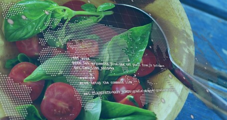 Showing wooden salad bowl with halved cherry tomatoes, basil, spoon on blue table, digital overlay