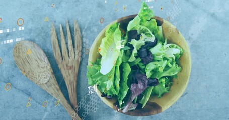 Showing wooden salad bowl holding lettuce on grey countertop, with wooden servers and tech overlays