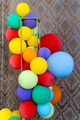 Colorful Balloons Celebration Against Golden Tapestry Wall.