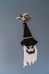 A modern FPV drone carries a spooky flying ghost with a witch hat, delivering a fun Halloween prank decoration.