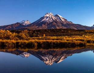 Fototapeta premium Snow-capped mountain reflected in still lake, autumn colors