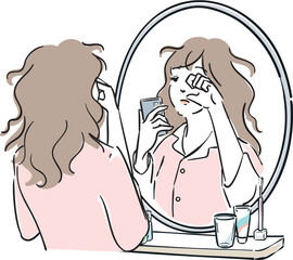 スマホを持って鏡の前に立つパジャマ姿の女性