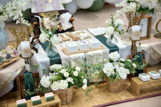 Elegant Korean doljanchi display with flower arrangements and wrapped gifts, symbolizing blessings and prosperity for the baby&rsquo;s first birthday celebration
