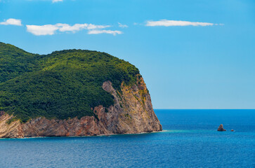 beautiful seascape, view of sea and high cliff covered with forest in the distance