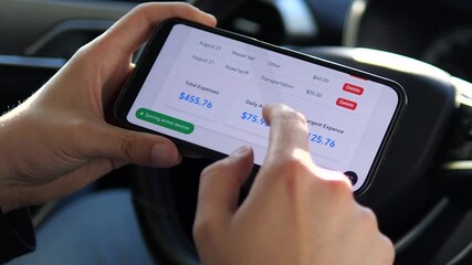 This close-up captures the process of financial review, with hands analyzing expenditure patterns through a mobile expense tracker while taking a moment in the vehicle. Ideal for FinTech promotions
