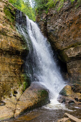 Waterfall cascading over rock ledge in forest