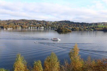 October Gold. High view looking down over a calm Windermere in the English Lake District with Leisure craft on the water.