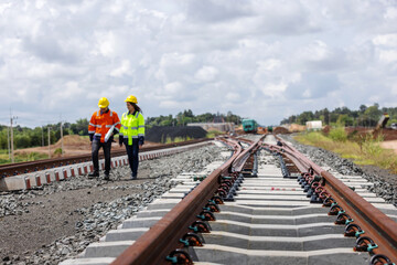 Obraz premium Railway track perspective with engineers in background, infrastructure construction and transportation concept