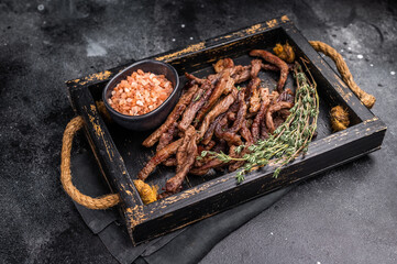 Beef fritter, Deep fried beef tender strips, sliced meat in a tray. black background. top view