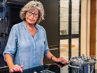 Senior woman cooking healthy meal in modern kitchen