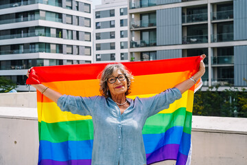 Senior woman holding rainbow flag celebrating diversity