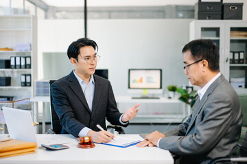 Lawyer advising client on contract signing in modern office, with gavel and scales of justice. Perfect for law, finance, consulting, or business concepts.