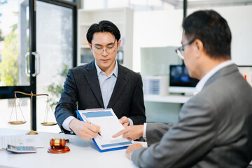 Lawyer advising client on contract signing in modern office, with gavel and scales of justice. Perfect for law, finance, consulting, or business concepts.