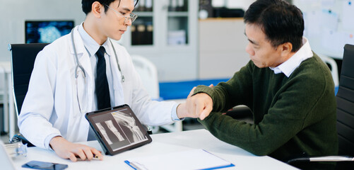 Doctor explaining knee X-ray results to patient in clinic, symbolizing orthopedic diagnosis, treatment, and modern healthcare consultation.