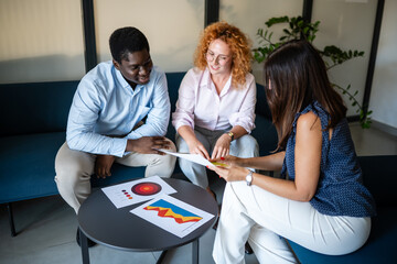 Team of diverse business colleagues analyzing data charts together