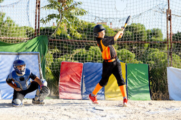 Young boys practicing baseball, batter swinging