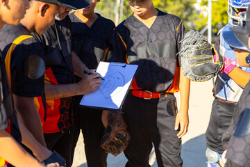 Baseball coach explaining strategy to youth team