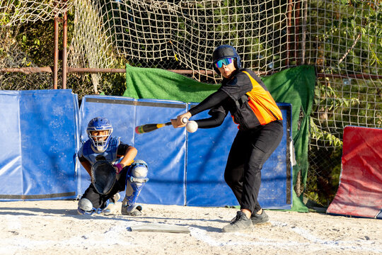 Batter hitting softball during a youth game - Powered by Adobe