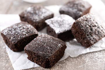 Homemade chocolate brownies with sugar powder on wooden table