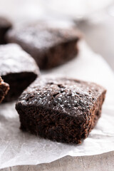 Homemade chocolate brownies with sugar powder on wooden table